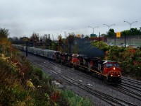 Heavy rain is falling as CN 527 crosses over to Track DX5 with four units and port traffic up front.