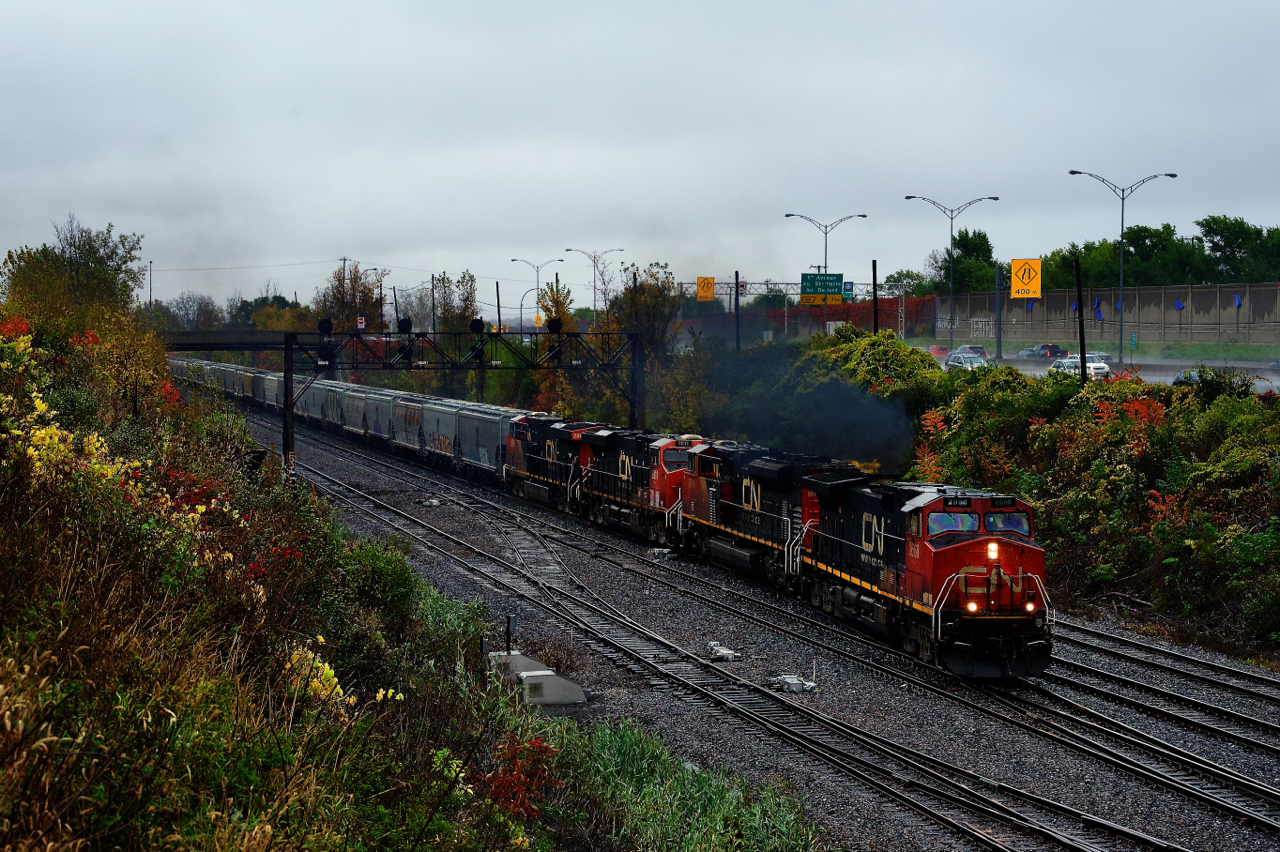 Heavy rain is falling as CN 527 crosses over to Track DX5 with four units and port traffic up front.
