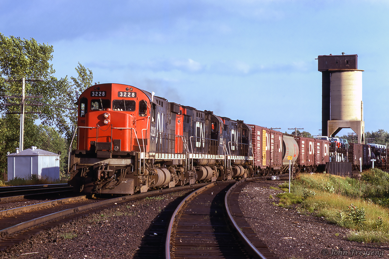 A westbound extra from Mac Yard to Capreol heads into the evening sun at Washago.Scan and editing by Jacob Patterson.
