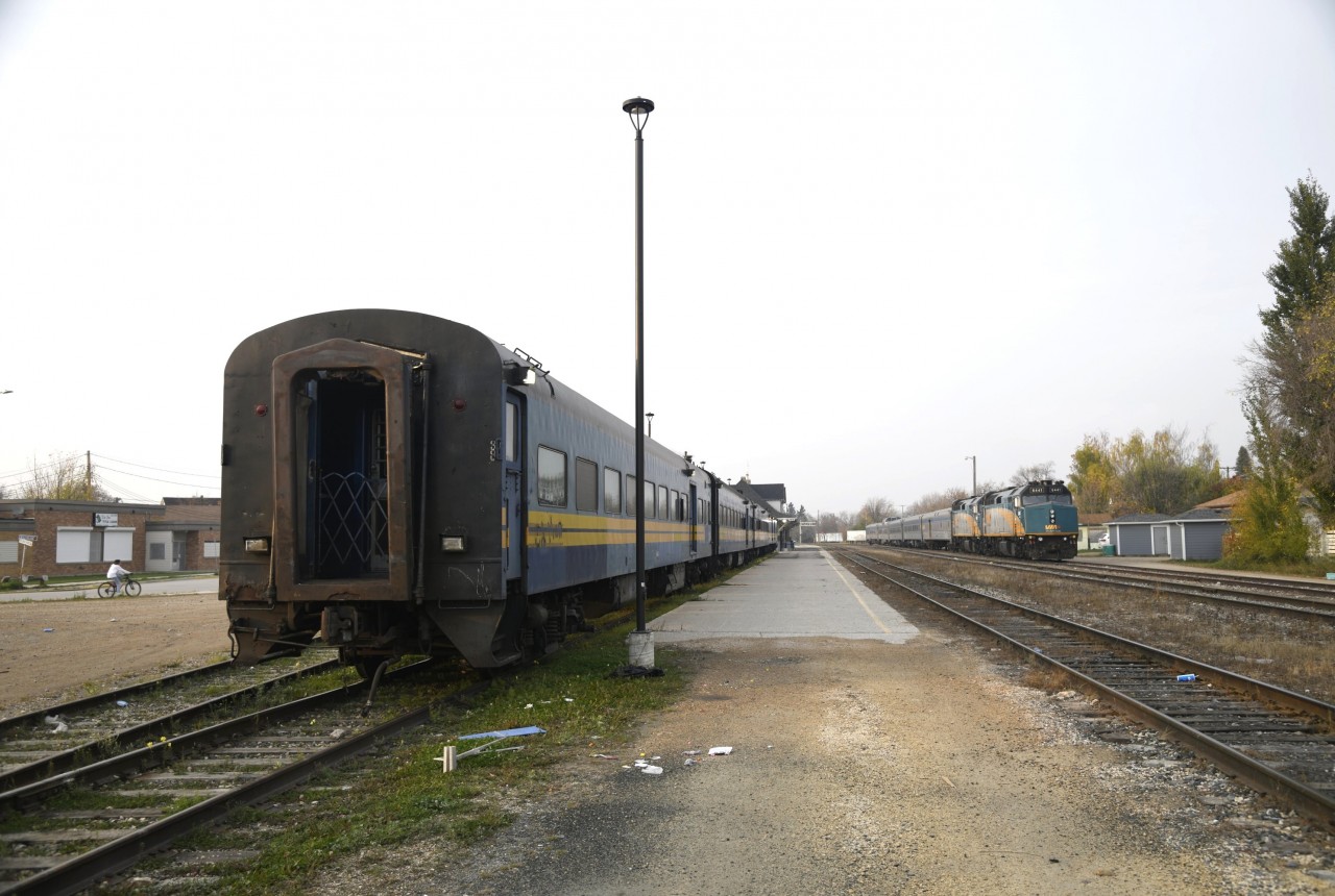 VIA blue and VIA stainless steel  
KRC 290 The Pukatawagan Mixed had pulled into The Pas about 20 minutes before this shot. Passengers and baggage were swiftly unloaded and the blue ex-VIA, exx-CN passenger cars were shoved into VIA storage track PZ70 to wait for the next trip north. 
Meanwhile, VIA 692 The Hudson Bay with its Budd stainless steel consist idles away on Fence Track PZ89 across from the beautiful station building waiting to depart southbound in about 8 hours at 02:30. 
I heard a rumour while in The Pas that KRC might be acquiring some ex-Amtrak double deck passenger equipment to replace the very aged blue passenger fleet currently in service. I'll believe that when I see it!!