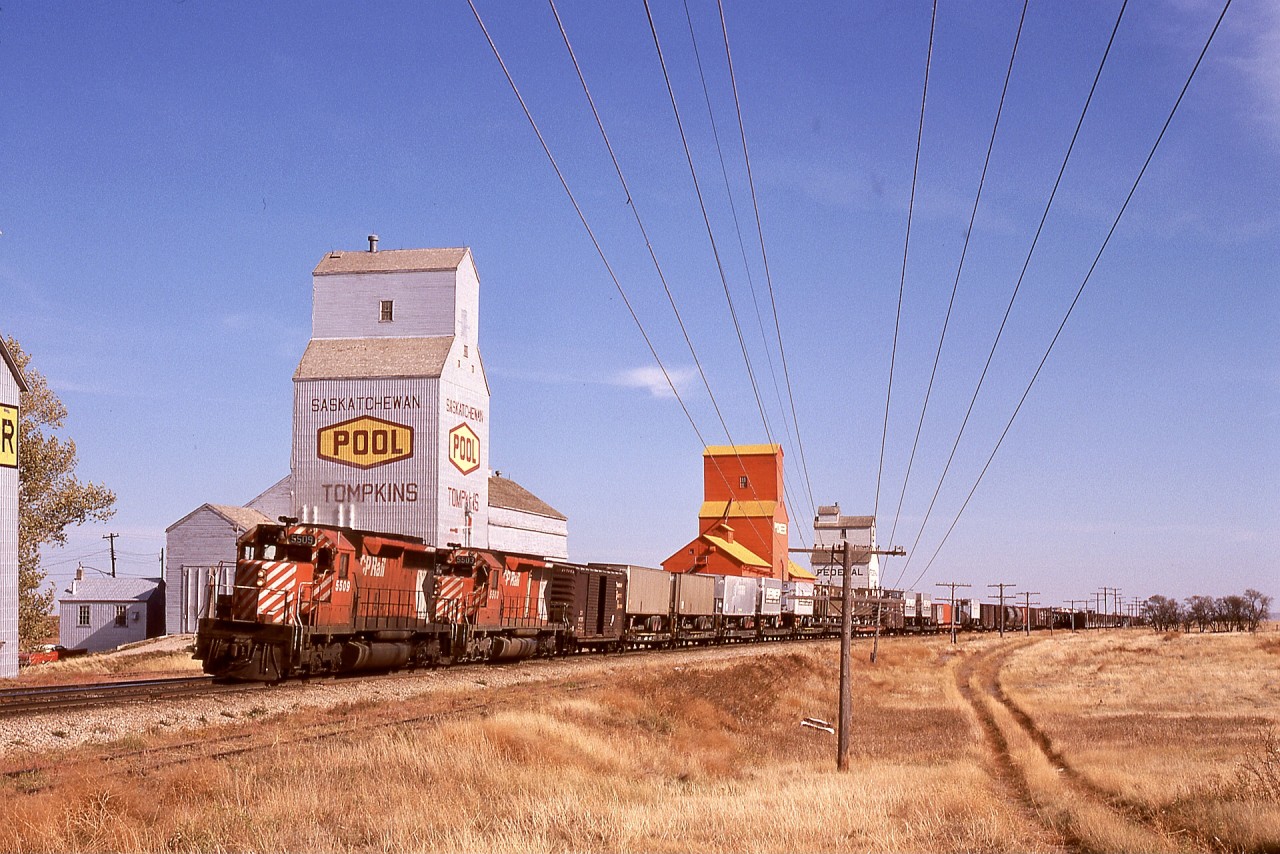 While 110 SD40-2 units were available on CP in 1974, it was not unusual to see a high-priority train like number 965 powered by a pair of plain SD40s out of the fleet total of 65 units.  Here, on Tuesday 1974-10-01 on my first Saskatchewan road trip, 5509 + 5503 are eight years old as they scoot by the elevators at Tompkins, 50 miles west of the previous crew change point at Swift Current.

Regard that glorious Saskatchewan sky.  Combine that with the friendly people there, and it is no wonder this west coast kid gained a strong appreciation for prairie railroading.  CP management folks were rather surprised when I happily accepted a temporary winter assignment to work there (based out of Moose Jaw) twenty years later.  Little did they know!