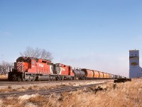 West of Swift Current by 67 miles on the Maple Creek subdivision, and with 80 miles to go to reach the next crew change point at Medicine Hat in Alberta, a combination of one SD40-2 (5677) and one GP9 (8657) has a westward train rolling by the lone grain elevator at Piapot (named after Cree chief Payipwat) in Saskatchewan on Thursday 1976-10-14.  

<p>If that date rings a bell, perhaps it is because it was the day a Canada-wide day of protest or general strike occurred due to a federal wage control program.

<p>If the Piapot grain elevator is recognized, possibly that is related to a news photo of it being moved by road in January 1979 (to where I do not know, possibly a museum).  Check https://www.researchgate.net/figure/Changes-in-the-collection-and-cleaning-of-grain-led-to-the-near-elimination-of-grain_fig5_338035679 for one version.
