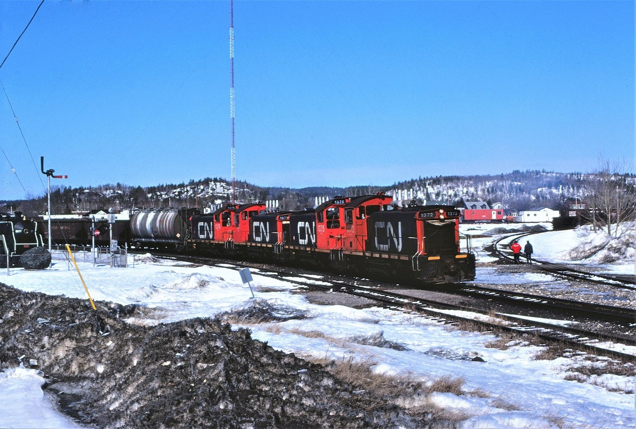 The ugly side of winter shows its true colours as the daily Sudbury Turn heads out of Capreol, Ontario on April 8th, 1982.  The railway made the museum remove the blades from train order mast as it "might confuse" operating crews.  The railway would not accept both blades displaying clear or green.  Four SW1200RS units (1372 1375 1373 and 1376 this day) were standard power for the job in 1982.