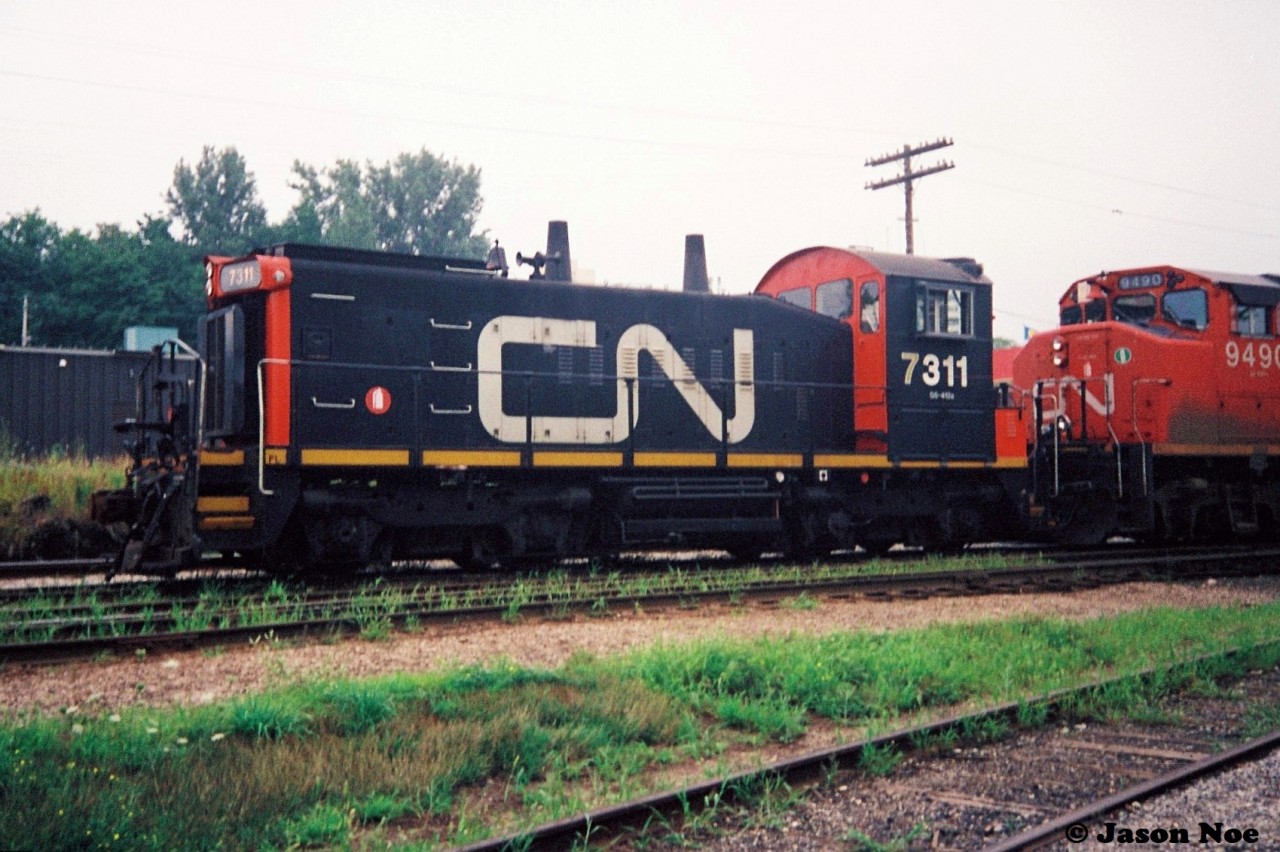 CN 421 is viewed waiting at the Kitchener yard for the 15:30 Kitchener Job to return from the Huron Park Spur with their lift of newly built frames from the Budd Plant. 421's consist included; 9560, 9620, 9490 and 7311.  SW1200RSm 7311 was likely heading to London for work in the yard.