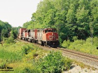 During a summer afternoon, a southbound CN train with 9638, 9554 and 9403 is approaching the crossing at Rosseau Road, which is south of Parry Sound, Ontario on CN’s Bala Subdivision. 
