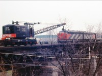 Here is another picture of the work gang on the Bronte creek CNR bridge laying down some rail with the help of CNR American self propelled crane as an eastbound CNR passenger rumbles by on the south track.