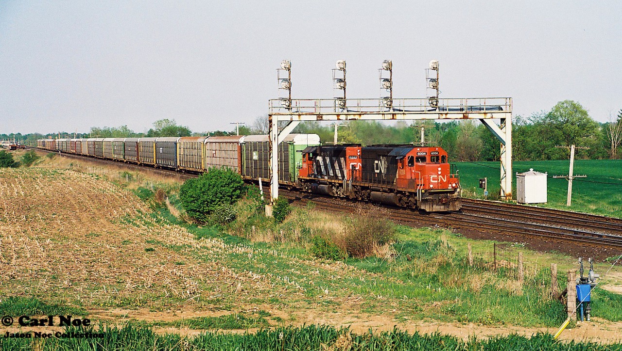 During a spring evening, a short CN 271 with SD40u 6004 and SD40 5052 are viewed heading westbound under the Paris West signal bridge on the Dundas Subdivision.