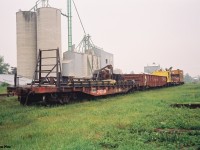 During a hazy summer afternoon, CP work equipment is seen in the town of Ayr, Ontario on the Galt Subdivision. The equipment includes flat car 421364, a gondola, a crane as well as CP caboose 434501. June 20, 1993.