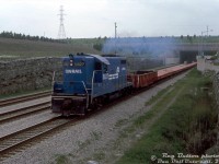 Having changed paint schemes four times but still working on home territory, Conrail GP7 5827 (<a href=http://www.railpictures.ca/?attachment_id=41004><b>ex-PC 5827</b></a>, exx-NYC 5827, originally built as C&O 5729 by GMD London) speeds through the Townline Tunnel on Conrail's Canada Division (former NYC/CASO/MCRR line) near Welland with a short train of CP cars. In two years, CN and CP would purchase the old CASO line from Conrail, and their longtime-assigned Canadian-built Geeps such as 5827 would be retired and sold off or scrapped.
<br><br>
<i>Reg Button photo, Dan Dell'Unto collection slide.</i>