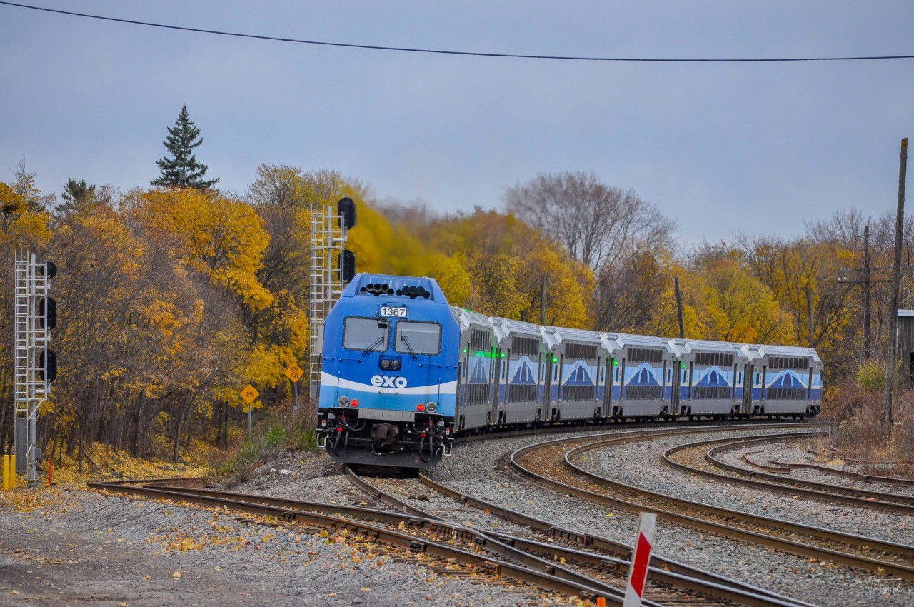 On November 21, 2023, just before the holiday train, an EXO train entered the curve west of Montréal-Ouest station. We can see that the trees still have their orange leaves.