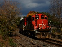 A suckerhole illuminates CN 500 as it leaves the Port of Montreal with a GP9 leader.