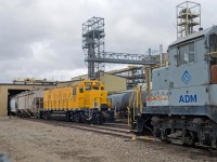 ADM's large facility on the west side of Lloydminster is home to a fleet of not less than four locomotives. Two units are visible here as a tired looking GP10 ADMX 8316 looks on as clean "LEAF" RSSX 2255 pulls empties through the building to spot on the next track over. 