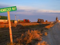 Grain is king on the Prairies, as evidenced by the aptly named Heimbecker Way - the road into Parish and Heimbecker's elevator at Oban, Saskatchewan.  In the background Q 11791 23 rolls past the elevator and two P&H units.