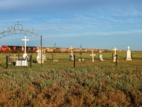 Potash loads from Cutarm, Saskatchewan highballs past the Pioneer Cemetary just east of Allan, Saskatchewan