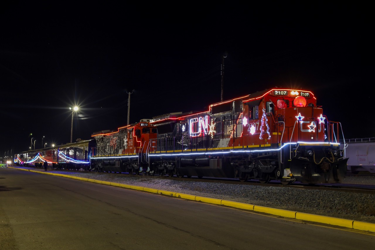 The 2023 edition of CN’s Christmas Express, is seen here at Edmonton Walker Yard preparing for a trip to St. Albert.  In what could be their last assignment, CN 2107 and CN 2112 are decked out in Christmas Lights with 4 Rocky Mountaineer coaches and a CN Transfer van on the tailend.