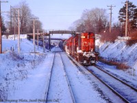 An eastbound freight for Mac Yard, led by RS18 3129, is seen waiting on the north track at Credit for 
our train, RDC-equipped VIA 661, to clear before proceeding eastward.  Just prior to <a href=https://www.railpictures.ca/?attachment_id=53239>crossing the Credit River,</a> both trains had been held for <a href=https://www.railpictures.ca/?attachment_id=53077>late running VIA 660</a> from Stratford.<br><br><i>John Freyseng Photo, Jacob Patterson Collection Slide.</i>