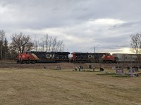 CN 3202 and CN 2888 shaking the ground of the dearly departed near Spruce Grove, Alberta as they head east towards Edmonton on Remembrance Day 2023.