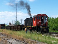 Hot day in July.  Trillium Railway MLW S-13 #110 switches in Merritton where the TRRY meets (and crosses) the CN Grimsby sub at mile 9:49.  The old CN yard at this location had fallen into disuse by this time as north end St. Catharines  business had pretty much dried up. The 110 was retired in 2021. I believe that is employee Marcel Lemal by the switch stand. He has retired as well. :o)