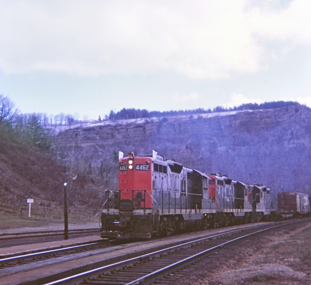 A gloomy day at Dundas, must have been cold with snow atop of the escarpment. Hanging out at Dundas station and 477 slogging up the grade with a trio of GP-9's. Great place to railfan. Kodak Instamatic memory from long ago.