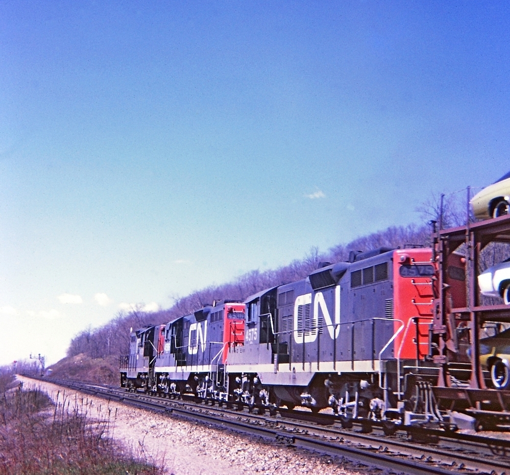 A sunny spring day. A "going away shot" Train 407 with CN 4575-4586-4520 westbound on the Dundas Hill. I'm thinking the location was near mile 3 point 5 and I was east of the Sydenham Road overpass. I had forgotten about the signal bridge until I scanned this slide. Kodak Instamatic Memories from long ago.