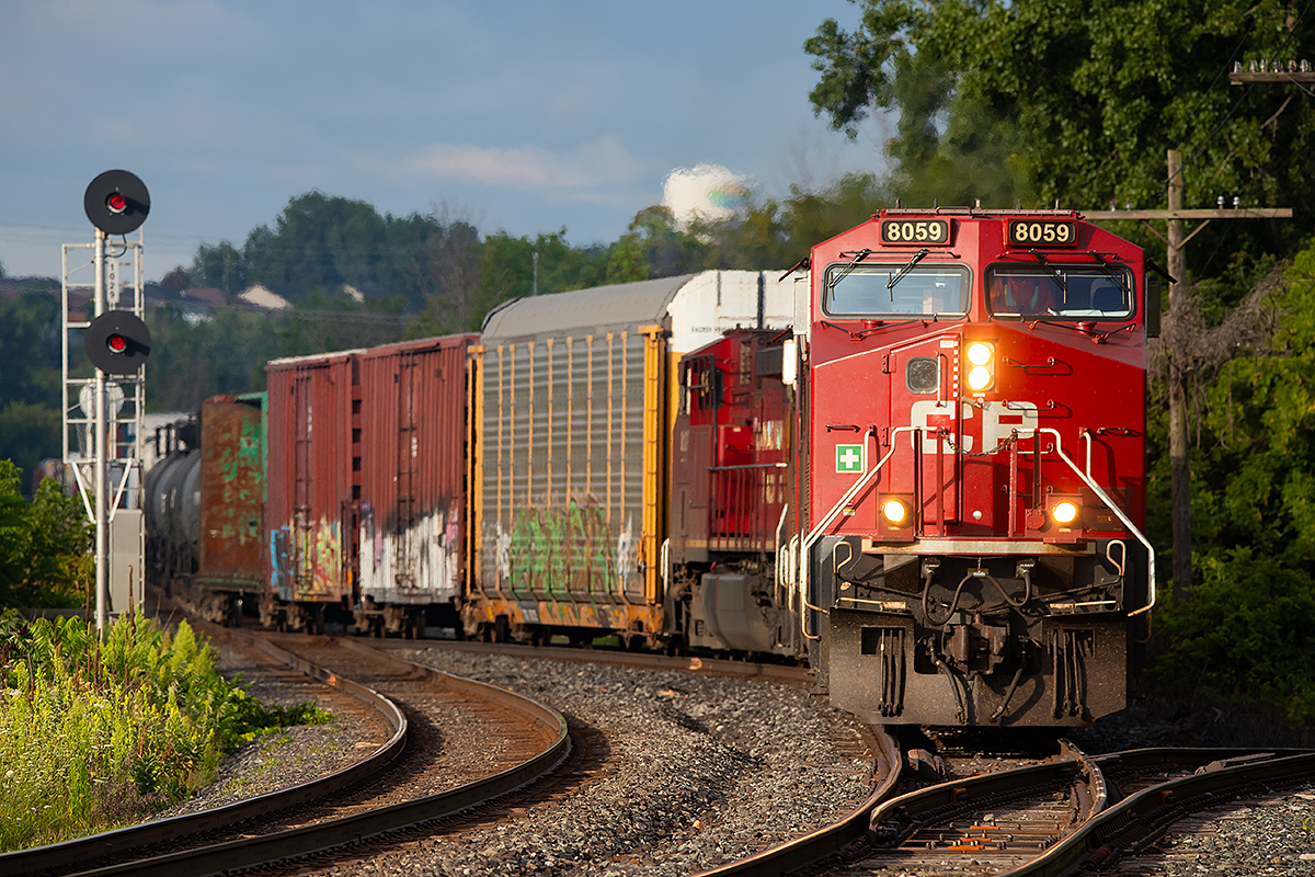 CP 8059 slowly leads an eastbound into the siding at Trenton where it will meet with a westbound.  The siding at Trenton has a couple level crossings which often lead to longer trains holding short of the siding atop the Trent River bridge, sometimes for hours at a time, while waiting for a meet.