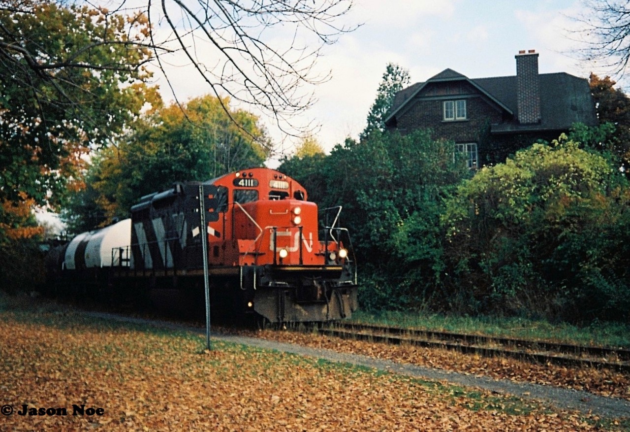 The last CN 15:30 Kitchener Job that I photographed going to Elmira in 1993, is viewed approaching Willow Street in Waterloo, Ontario with GP9RM 4111 leading two tank cars and caboose 79883 on the Waterloo Spur.