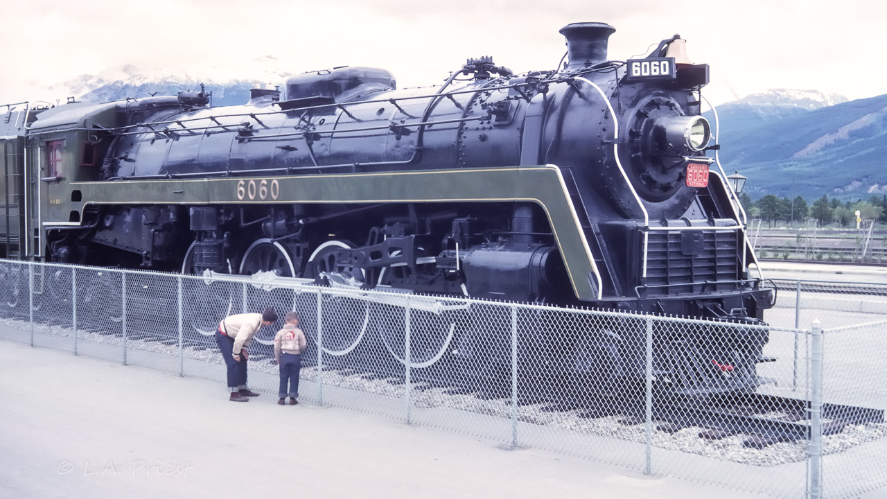 The date stamp on the Kodachrome reads Jul 62. Mr. Homes will only have just set the 6060 up on it's viewing platform in Jasper. It will be another 10 years before the 6060 is freed to the rails and allowed to roam them once more. A couple of master mechanics are checking out the running gear :^), from our summer of 62 vacation.