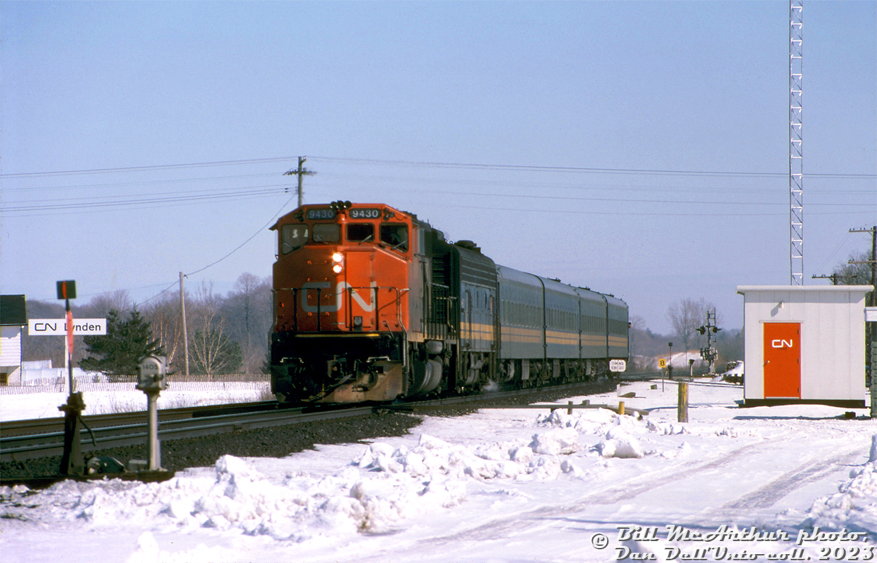 Borrowed CN GP40-2L(W) 9430 leads VIA train #73 westbound through Lynden on CN's Dundas Sub, with VIA F9B 6630 trailing ahead of four of the blue & yellow fleet. 

CN's GMD GP40-2L(W) group 9400-9449 were delivered in 1974 with faster 76mph gearing (60:17 gear ratio, instead of 62:17 gearing for regular max 65mph operation like the rest of the fleet). Some speculate this may have been for fast or express freight use. The units occasionally saw passenger service on VIA Rail, usually just one 9400 combined with a steam generator-equipped VIA unit that would provide steam heat to the passenger cars.

Bill McArthur photo, Dan Dell'Unto collection slide.