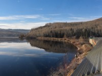 <b> Skirting the shore of Burns Lake </b> <br>
VIA 005 The Skeena is on its way from Prince George, BC to Prince Rupert, BC on the second day of its northwest trek. Just a mile or so from entering the town of Burns Lake, the locomotive and two-car consist (VIA 8102 coach, and VIA 8707 Kokanee Park) glide smoothly along the shore of the namesake lake. <br>
Once again I have the entire Park car to myself for hours at a time on this wonderful journey. :-) <br>
Another photo graciously edited by my friend Extra 5610 West.
