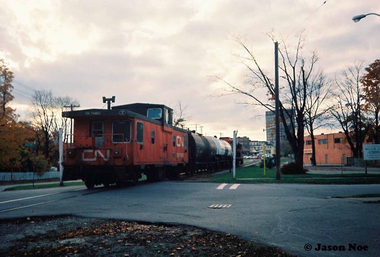 The last CN 15:30 Kitchener Job that I photographed going to Elmira in 1993, is viewed crossing Willow Street with GP9RM 4111 leading two tank cars and caboose 79883 heading into downtown Waterloo, Ontario on the Waterloo Spur.