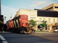 On the evening of August 18, 1993, the CN 15:30 Kitchener Job with GP9RM 4123 is viewed crossing King Street in downtown Waterloo, Ontario as it hauls two tank cars to Elmira on the Waterloo Spur. 
<br>
A follow-up photo on the same evening can be seen here.
<br>
http://www.railpictures.ca/?attachment_id=35441
