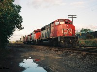 CN train 421 is viewed at the Kitchener yard with 9527, 9622 and 4128 along with caboose 79436. The train had arrived light power in Kitchener from Guelph and proceeded to lift the caboose at the Kitchener yard as well as the loaded cars with recently built Budd automobile frames seen in the background. Once all their work was completed, 421 would eventually depart towards London with 79436 in its rightful spot on the tail-end.