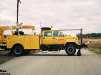 In 1993, CP had officially changed its corporate logo to “CP Rail System” utilizing parts of the American and Canadian flags. Any new locomotive rebuilds and repaints started appearing with the new symbol as the year progressed. The railway also applied logos on other rail equipment including their fleet of maintenance vehicles.
<br>
Here an eastbound CP track maintenance truck crosses Trussler Road, just west of Ayr, Ontario by the east siding switch at Wolverton. The new logos are seen adorning the doors of the vehicle.
