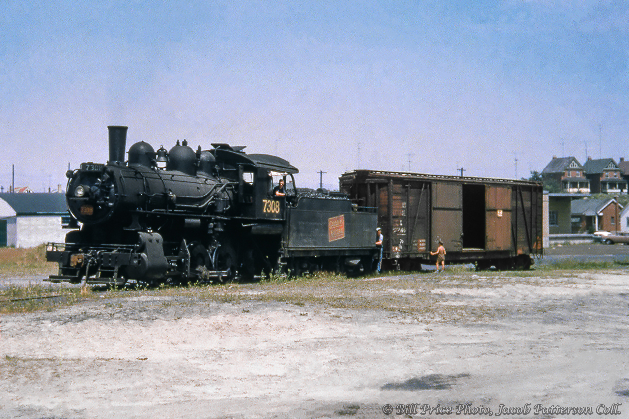 CNR O-15-b, 0-6-0 7308 is seen working along Kitchener's St. Leger Street Spur, switching the property at 150 St. Leger, the site presently occupied by Canada Post.  In the background, beyond the boxcar, the house at 60 Edwin Street can be seen, as well as two houses above at 16 and 20 Hill Street.Bill Price Photo, Jacob Patterson Collection Slide.