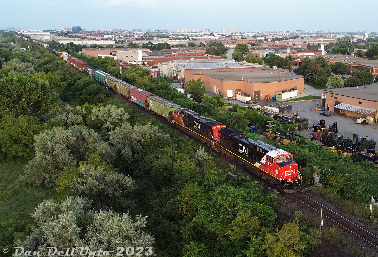 With the sun going down and dinner hour approaching, it was time to land the drone and head back home...almost. After hearing CN #399 depart MacMillan Yard, sticking around for one last train was in order. Fresh-looking rebuilt AC44C6M CN 3323 (outshopped six months earlier by Wabtec/GE) leads ES44AC 2955 through the equilateral turnouts at the east end of Humber on the Halton Sub, about to cross Islington Avenue and then the Humber River bridge. Manufacturing and factory buildings along Vinyl Court are visible on one side of the tracks, including the local forklift manufacturing facility. On the other side is grown-in empty land between the tracks and Highway 407 ETR (I've been informed that, years before the 407, it was once all farmland full of onion fields back in the day, that this City of Vaughan Archives image confirms).