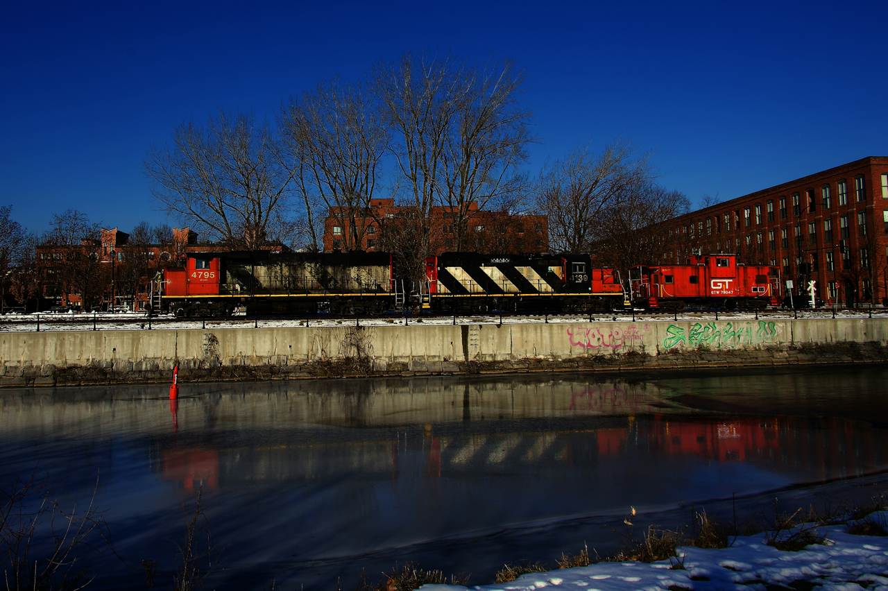 After dropping off cars at Ardent Mills, CN 500 is heading west along the frozen Lachine Canal. Soon it will use a runaround track to move the caboose to the west end of the power, before heading to Track 29 to pick up grain cars.