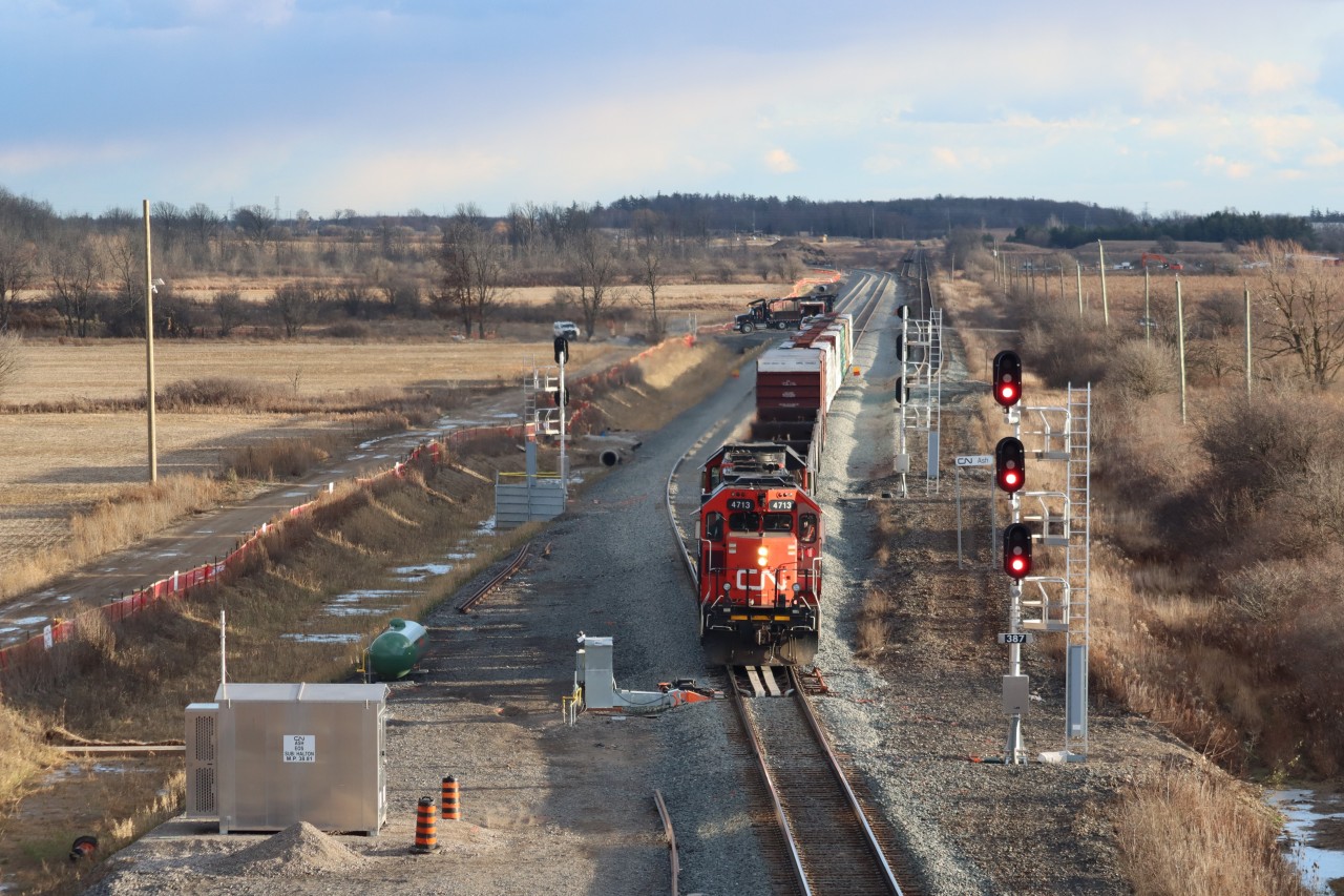 L551 operates westward through the relocated station Ash, Mile 38.8 Halton Sub. via a new #20 turnout and colour light signals. L551 is operating on the north track of the double track realignment and diversion tracks between Mile 38.8 and Mile 41.00 Halton Sub.. Portions of the former single track, #20 turnout at the former Ash (Mile 39.5) and double track can be seen on the right (north side) where the diversion track swings left (south). Aligned to the south, the diversion tracks rejoin the existing Halton Sub. alignment on the west side of the former Lower Baseline Road crossing at grade at approximately Mile 41.00. The track and signal changes are associated with the construction of the CN Milton Logistics Hub.