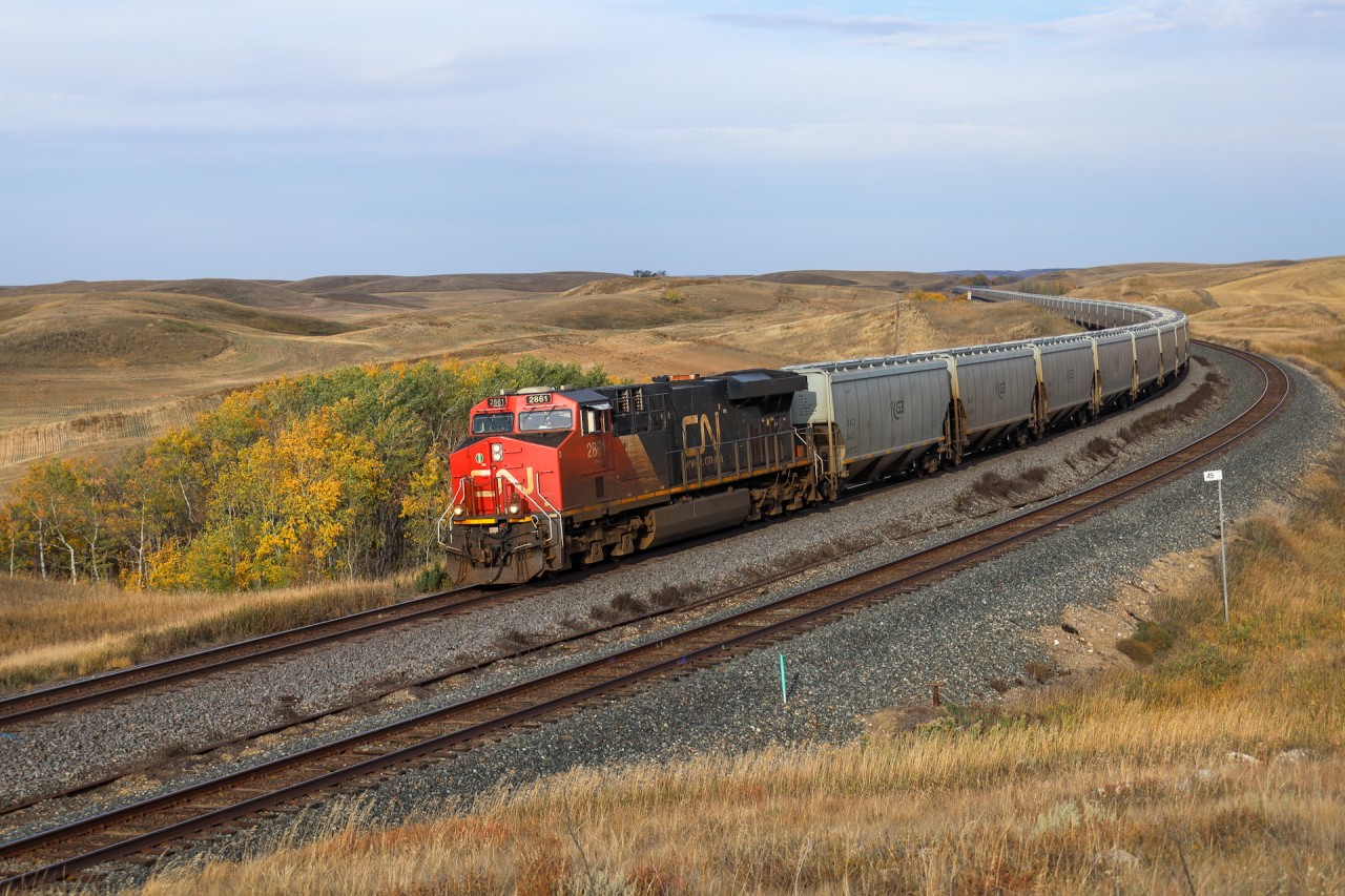G 84451 25 an empty G3 grain shuttle for Booth, Saskatchewan cruises through Keppel on a windy September morning.  Keppel is a neat location just east of Biggar, where the CPKC Wilkie Sub runs along side the CN Watrous Sub through some rolling hills that break the monotony of the Saskatchewan Prairie.