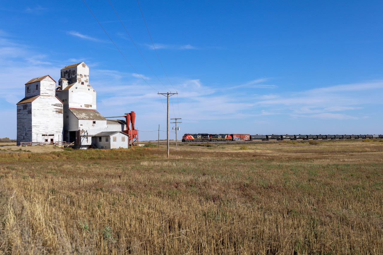 M 31341 25 rolls past the Prairie Sky Scraper at Leney, Saskatchewan.