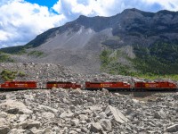 In the early morning hours of April 29, 1903 the peaceful mountain town of Frank, Alberta was awakened by the thunderous sound of a rock slide on Turtle Mountain. Within 100 seconds, 110 million tons of rock fell into the valley below at speeds approaching 70 miles an hour. When it was all said and done, over 90 people had lost their lives and 3 square kilometers of the valley were buried by rock averaging 46ft deep, with some places being buried 150ft deep. At the time, this was the largest recorded land slide in Canadian History and the CP mainline was buried for approximately 1.2 miles. Within 3 weeks the railway had blasted a path through and re-opened the Crowsnest Sub. The eastern end of Frank, Alberta was devastated by the slide and the town was relocated out of the path of Turtle Mountain.  Fast forward 119 years after the devastating slide, we see CP 219 with CP 8000, CP 7046, CP 5792 and CP 5973, with CN 3905 on the tailend, climbing through the debris field at Frank Slife. 