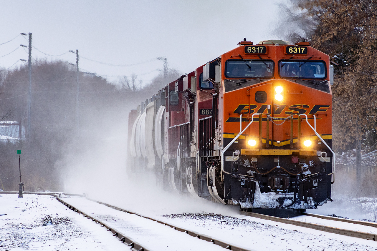238 is usually 2 units. So on this day, it was either particularly heavy, or one unit had dynamic brake issues, and CP grabbed whatever was available. In this case, to a foamers delight, it happened to be a BNSF GE; probably off a 734 that did the honours. Kicking up a little bit of what has been very rare snow his fall, 238 heads for Buffalo passing what's left of the Killean Siding.