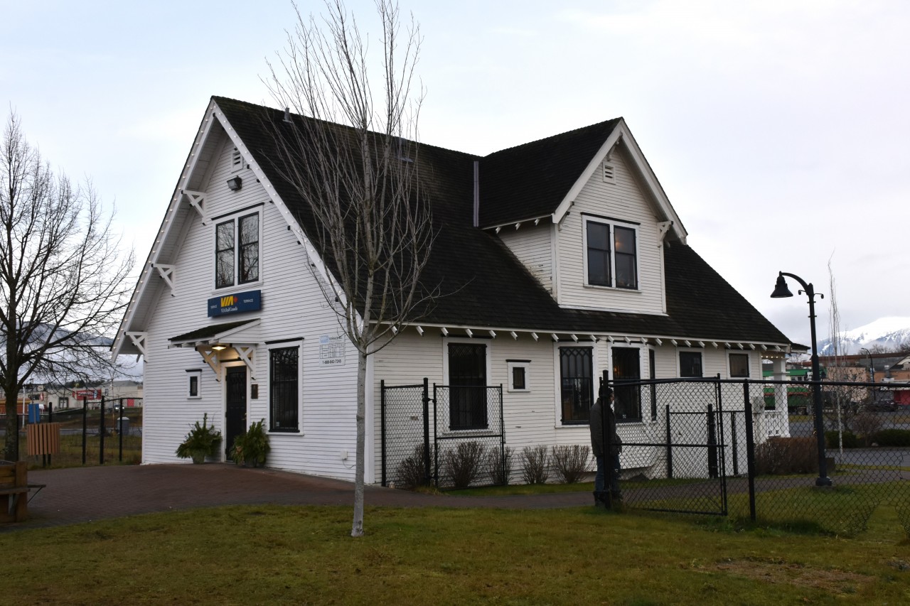 George Little House  
Is also known as the Terrace, BC VIA Rail station. 
The clouds are below the peaks to the left of the frame while the sun is desperately trying to break out and shine on the mountain tops at the right. 
The back of the house faces the CN mainline at Mile 0.0 of the CN Skeena Sub., and Mile 131.9 of the CN Bulkley Sub. The building is shared with the local tourism office.  https://www.georgelittlehouse.com/