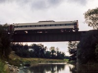 CN 6116 is seen shoving the consist of three RDCs (6120, 6003, 6116) westbound in preparation for a runpast on the Goderich Sub, crossing the Thames River at Mitchell.  The trip ran from Toronto - London via the Oakville and Dundas subdivisions to reach the <a href=https://www.railpictures.ca/?attachment_id=38375>GMD plant for a tour.</a> Following the tour, the trip departed London for Hyde Park, taking the Exeter Sub north to Clinton and on to Goderich. Returning to Stratford, via the Drumbo sub to Paris, and back to Toronto.  Bruce Acheson captured the train later in the evening during a <a href=https://www.railpictures.ca/?attachment_id=48021>runpast on the Drumbo Sub.</a><br><br><i>Original Photographer Unknown, Jacob Patterson Collection Slide.</i>