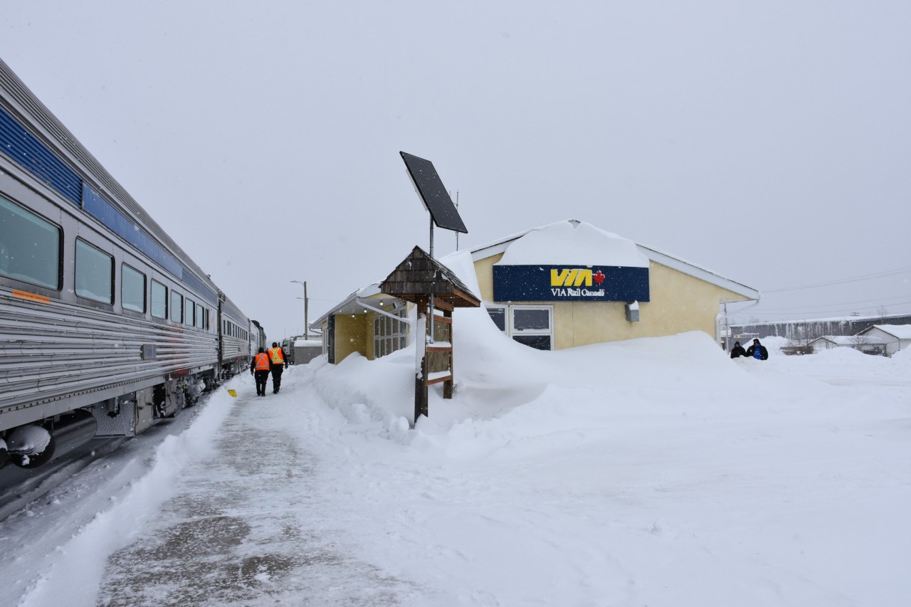 Get the shovels out!  
Heavy snow and a strong wind have left a mighty big drift all around the Thompson station and is now making its way up and over the roof of the building. The HBR front end loader has gone down the platform to make a clear path for passengers to detrain, and, for the fuel truck to make its way to the locomotives. 
There was no walking into town on this blustery day. 15 minutes outside to snap a few pics, then back on board to the Skyline car for a large hot chocolate.