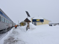 <b> Get the shovels out! </b> <br>
Heavy snow and a strong wind have left a mighty big drift all around the Thompson station and is now making its way up and over the roof of the building. The HBR front end loader has gone down the platform to make a clear path for passengers to detrain, and, for the fuel truck to make its way to the locomotives. <br>
There was no walking into town on this blustery day. 15 minutes outside to snap a few pics, then back on board to the Skyline car for a large hot chocolate.