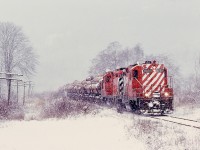 Canadian Pacific’s E&N Division on Vancouver Island handled Crown Zellerbach logs from Lake Cowichan to CZ’s dump into the sea at Ladysmith on trains named Nitinat for CZ’s Nitinat Logging Division.  On Tuesday 1980-01-08, a snowstorm north of Duncan at the village of Westholme highlighted the northbound Nitinat log loads, powered by CP GP9s 8689 and 8530, with the telephoto view nicely capturing the angled-outward white flags which distinguished that lead unit (and a few others) from the rest of the fleet.

<p>Completely unknown to me then, the last Nitinat log train ran just over one month later, 1980-02-13, with a happy-photographer reprieve when Pacific Logging used the same facilities for a few weeks to clear out their inventory of logs from Lake Cowichan.

<p>Considering the posting date, a very Merry Christmas to all.