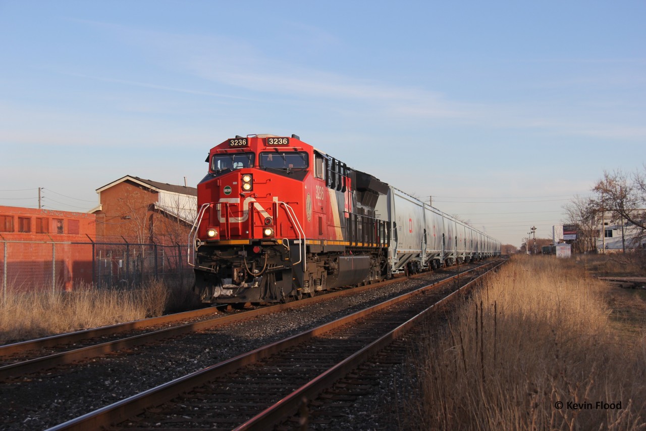 On a typical snowless January day in Hamilton, ON, CN 3236 is pictured leading a short, extra empty grain train with factory-fresh CN hoppers. During this time, CN ran a number of these extras. They were neat because they were unit trains, all the cars were brand-new, and all CN. Unfortunately, this one was shorter than some of the others that ran.