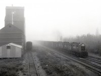 On Friday 1981-09-25, it was foggy in Leoville, SK, as a freight train from Meadow Lake returning to Prince Albert passed the grain elevator at 0848 CST, with a typical trio of RS-23 lightweight (for CN joint use branchline operation) units, 8018 + 8016 + 8015, for power.  34.2 more miles to reach CN rails at Debden, then 31.5+28.7+0.1+0.6 miles on four CN subdivisions (Big River, then Blaine Lake, Duck Lake and Tisdale) to reach CP rails at Prince Albert and a switchback route down to the CP yard, a spider’s web of lines.

<p> From https://www.traingeek.ca/wp/trains/class-1-railways/cp-saskatchewan/meadow-lake/:  “The subdivision was traded to CN in 1987 (?) in exchange for the CN Bengough subdivision. It was taken over by the Carlton Trail Railway in 1997.”  In 2008, decommissioning was announced, and it is now abandoned with the rails removed.