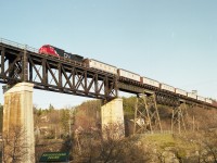 Crossing the majestic Parry Sound CP bridge, a CN work extra with a long train of Camp Cars behind CN 2585 takes advantage of the directional running in which CP and CN trains run north (read: west) and southward trains use the CN line thru town.  Sun is perfect on this structure in the late afternoon.