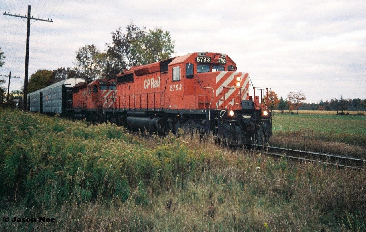 During an October afternoon, a CP westbound with SD40-2 5793 and SD40 5513 is paused at the Trussler Road crossing, just west of Ayr, for a meet with an eastbound from London, Ontario on the Galt Subdivision at Wolverton.